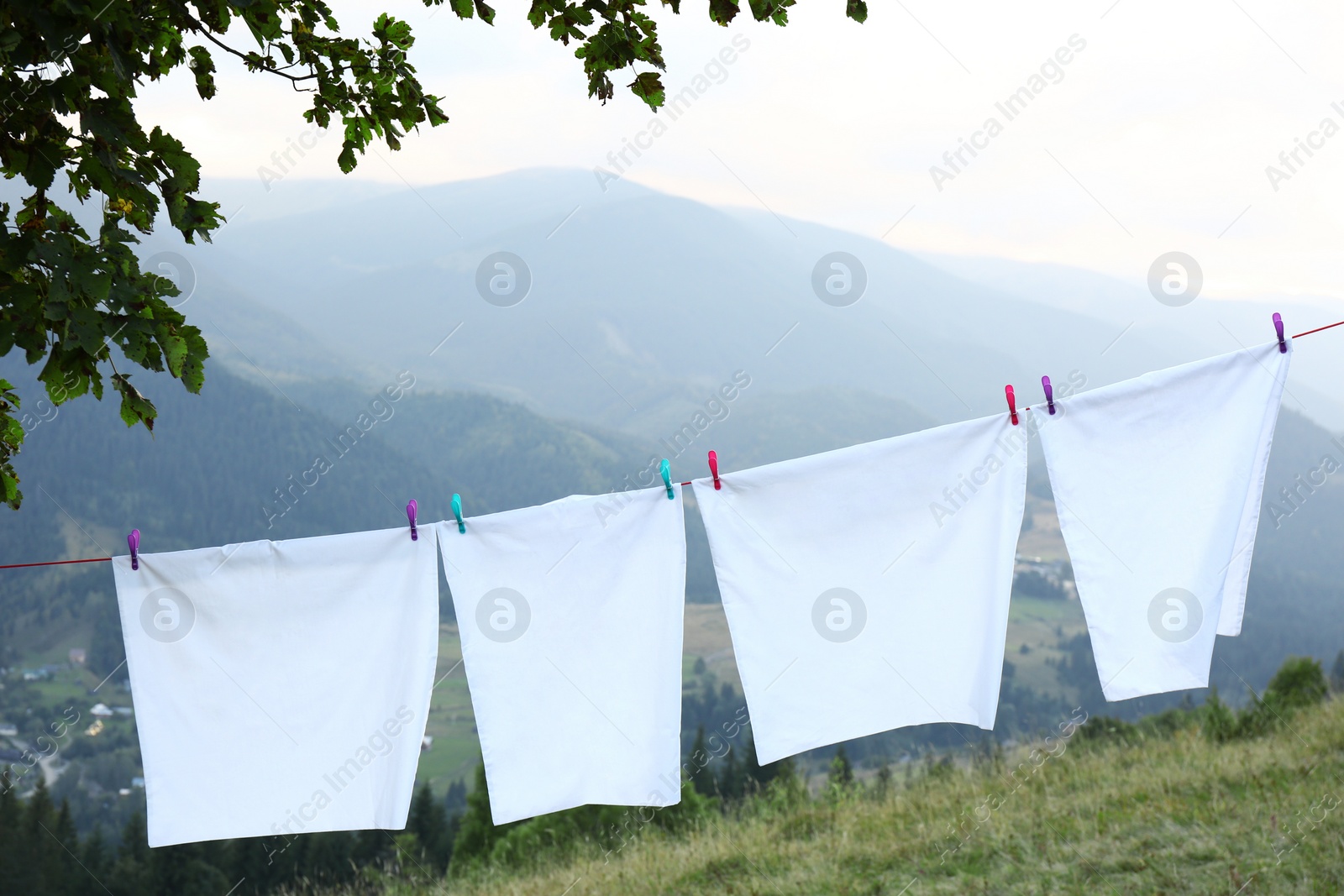 Photo of Bedclothes hanging on washing line in mountains