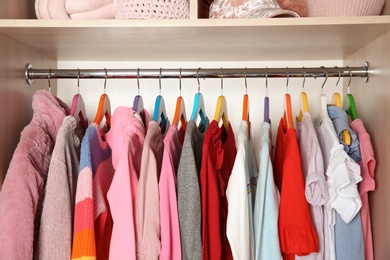 Photo of Wardrobe with stylish girl's clothes hanging on rack