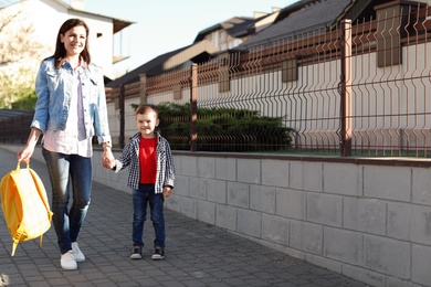 Young woman taking her little child to school