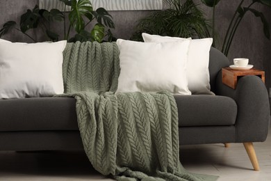 Photo of Soft white pillows and blanket on sofa indoors