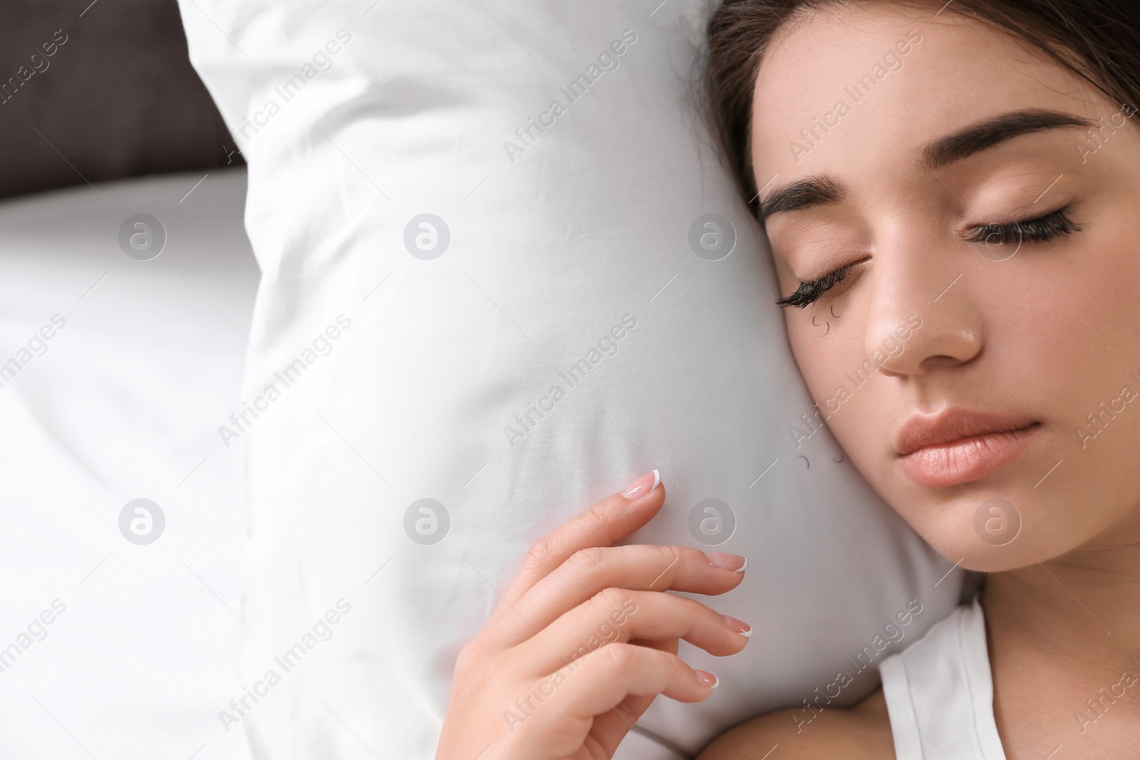 Photo of Young woman with eyelash loss problem sleeping in bed