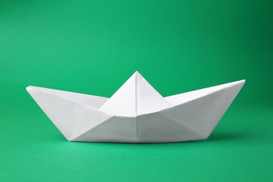 Photo of Origami art. Paper boat on green background