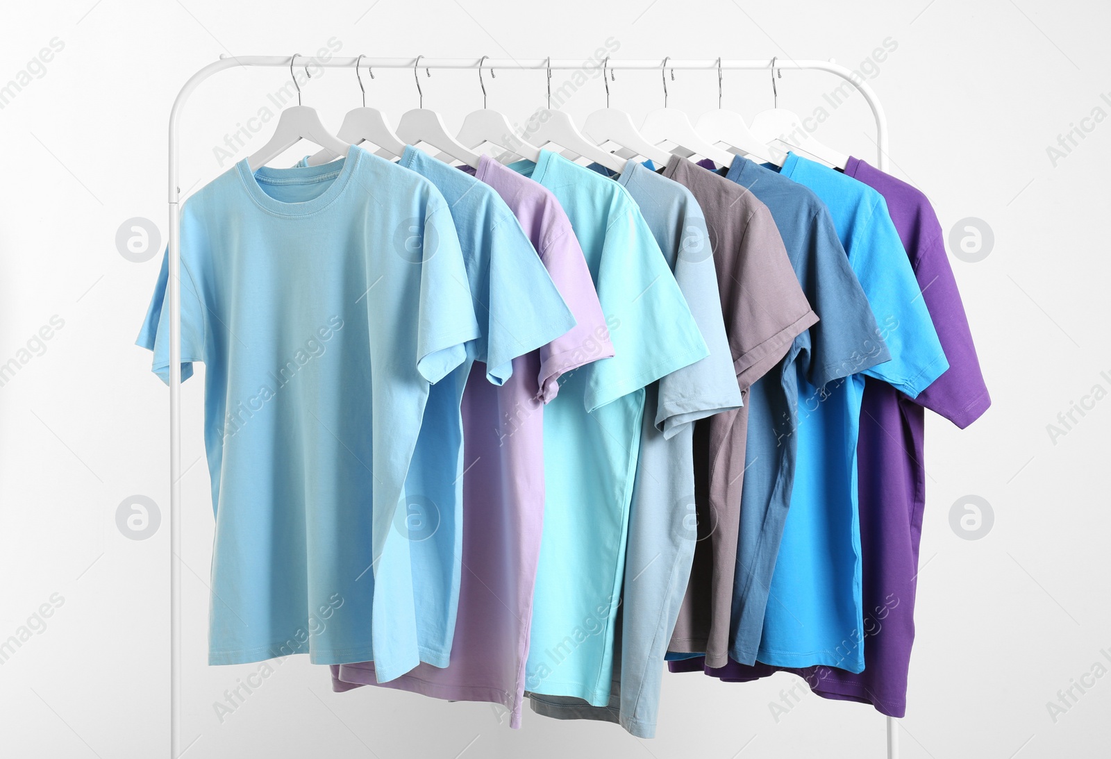 Photo of Men's clothes hanging on wardrobe rack against white background