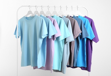 Men's clothes hanging on wardrobe rack against white background