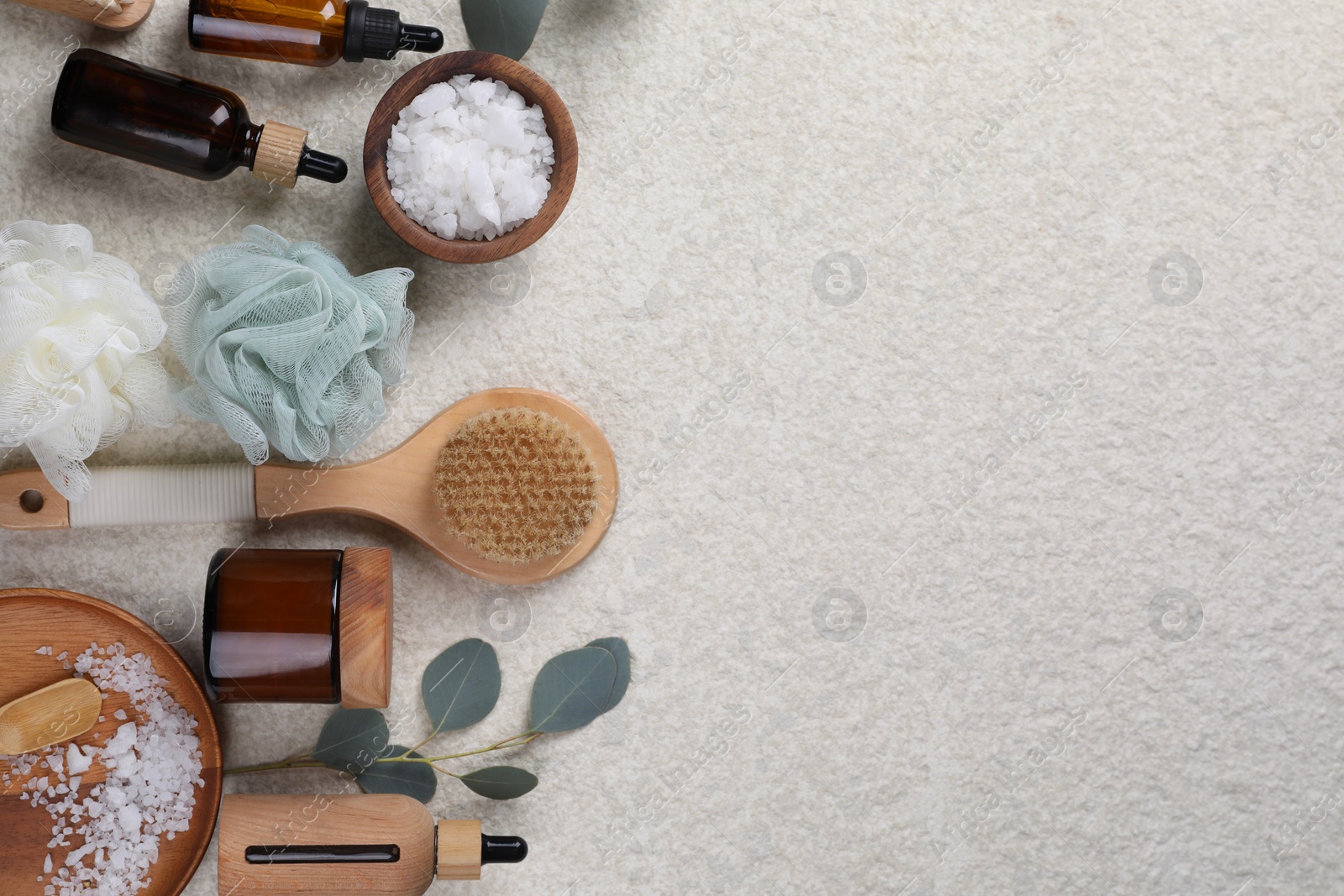 Photo of Flat lay composition with different spa products and eucalyptus branch on light grey textured table. Space for text