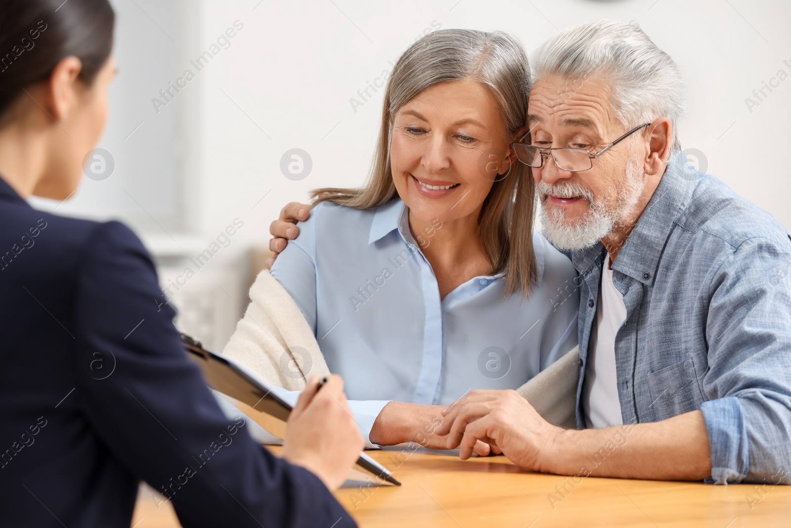 Photo of Notary consulting senior couple about Last Will and Testament in office