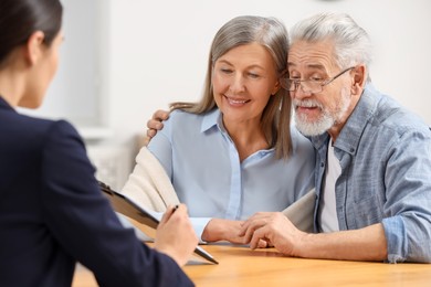 Notary consulting senior couple about Last Will and Testament in office