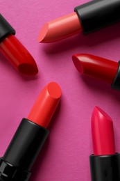 Beautiful lipsticks on pink background, flat lay