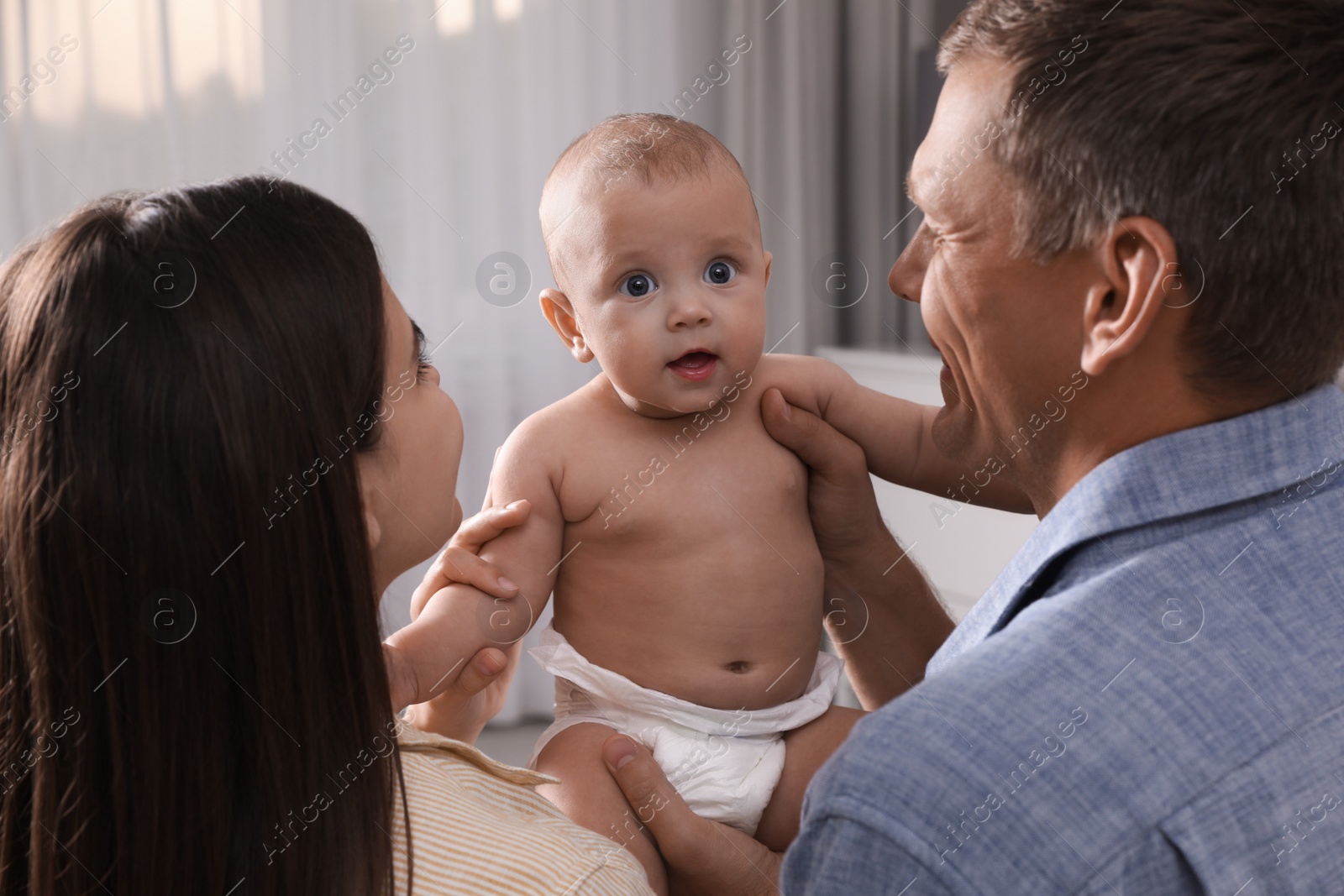 Photo of Happy family with their cute baby at home