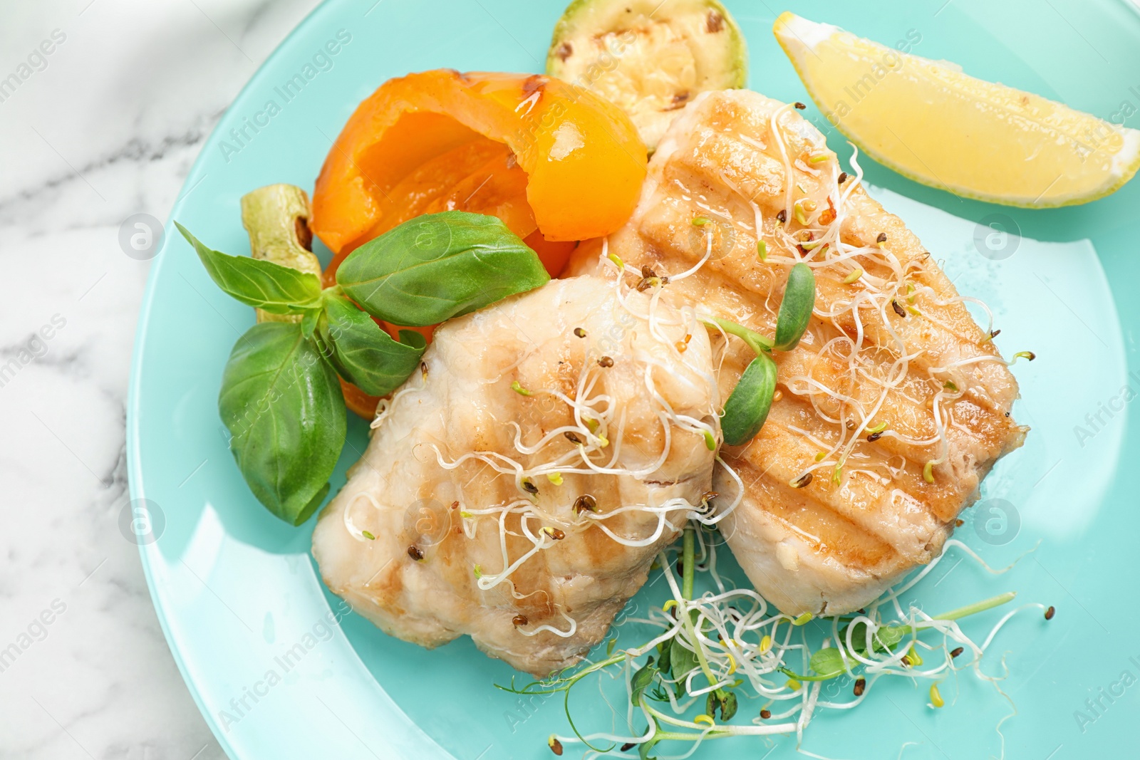 Photo of Tasty grilled fish on marble table, closeup