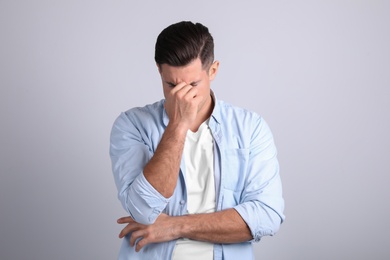 Photo of Portrait of stressed man on light background