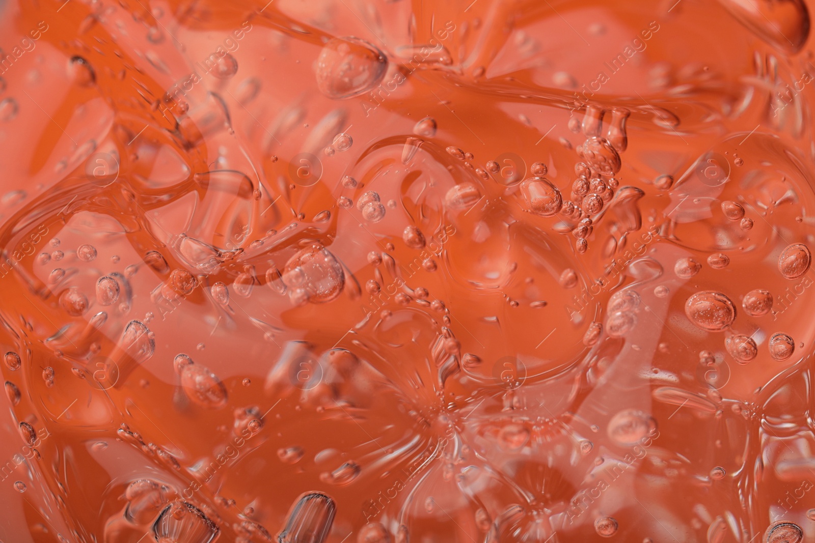 Photo of Pure transparent cosmetic gel on orange background, closeup