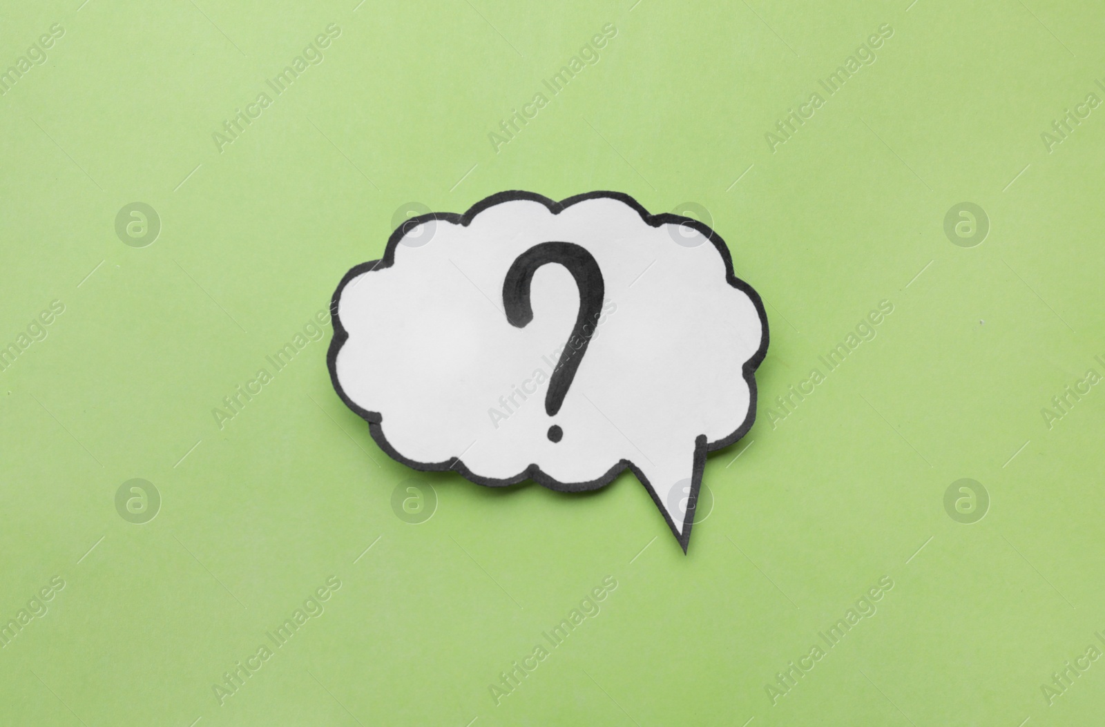 Photo of Paper speech bubble with question mark on green background, top view