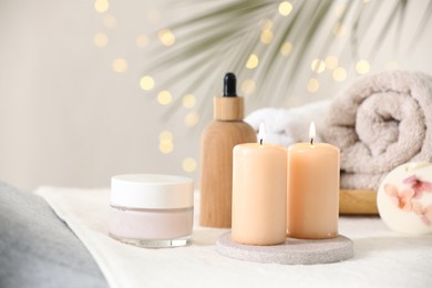 Photo of Spa composition. Burning candles and personal care products on soft surface