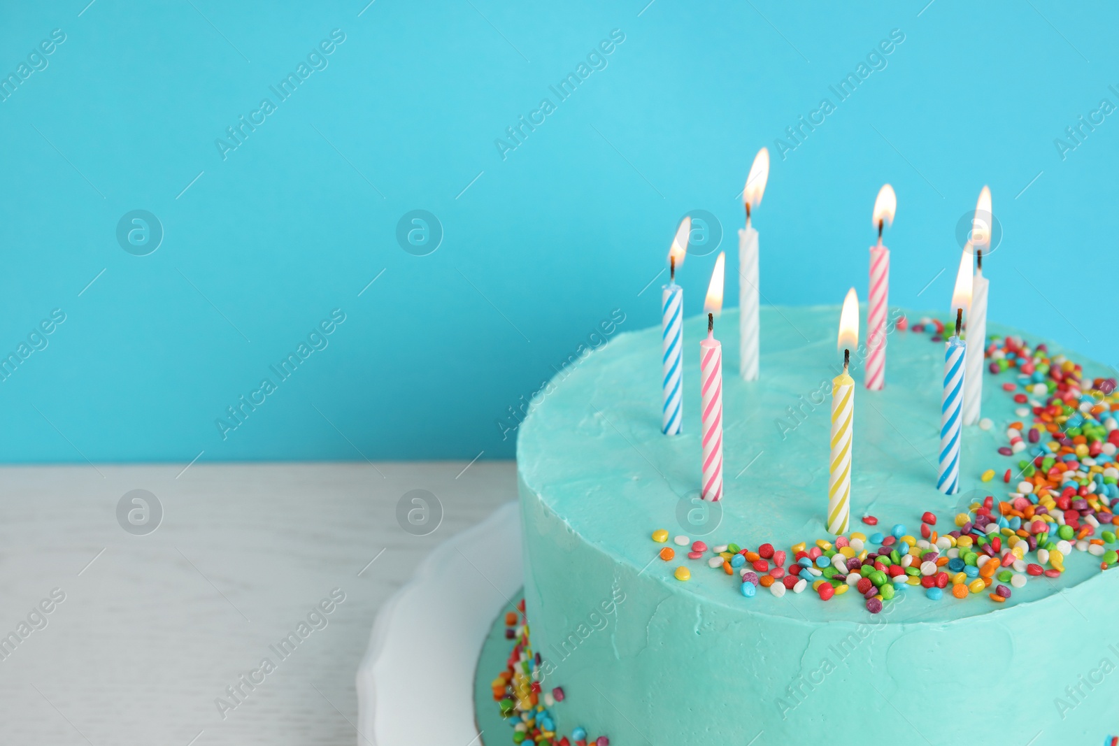 Photo of Fresh delicious birthday cake with candles on table against color background. Space for text