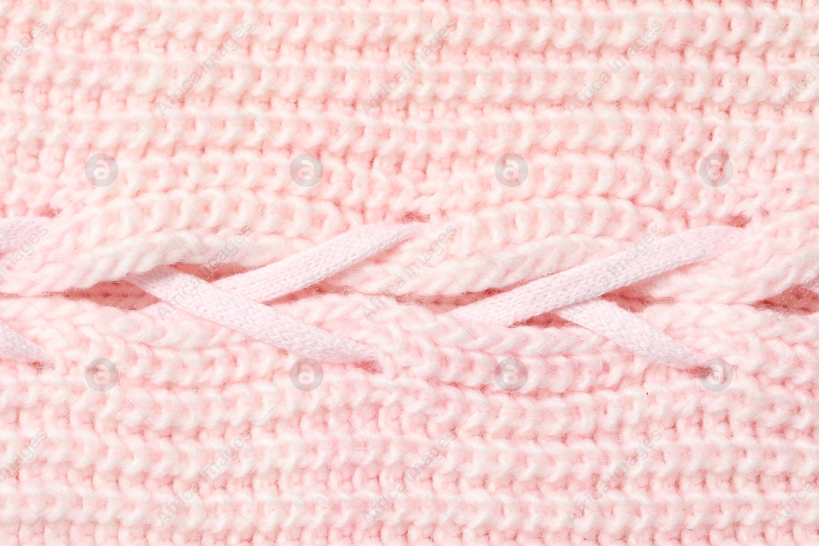 Photo of Texture of soft pink knitted fabric as background, top view