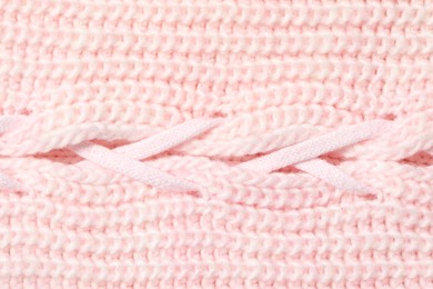 Texture of soft pink knitted fabric as background, top view