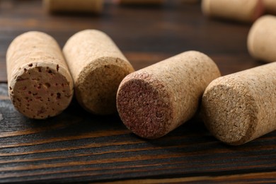 Corks of wine bottles on wooden table, closeup