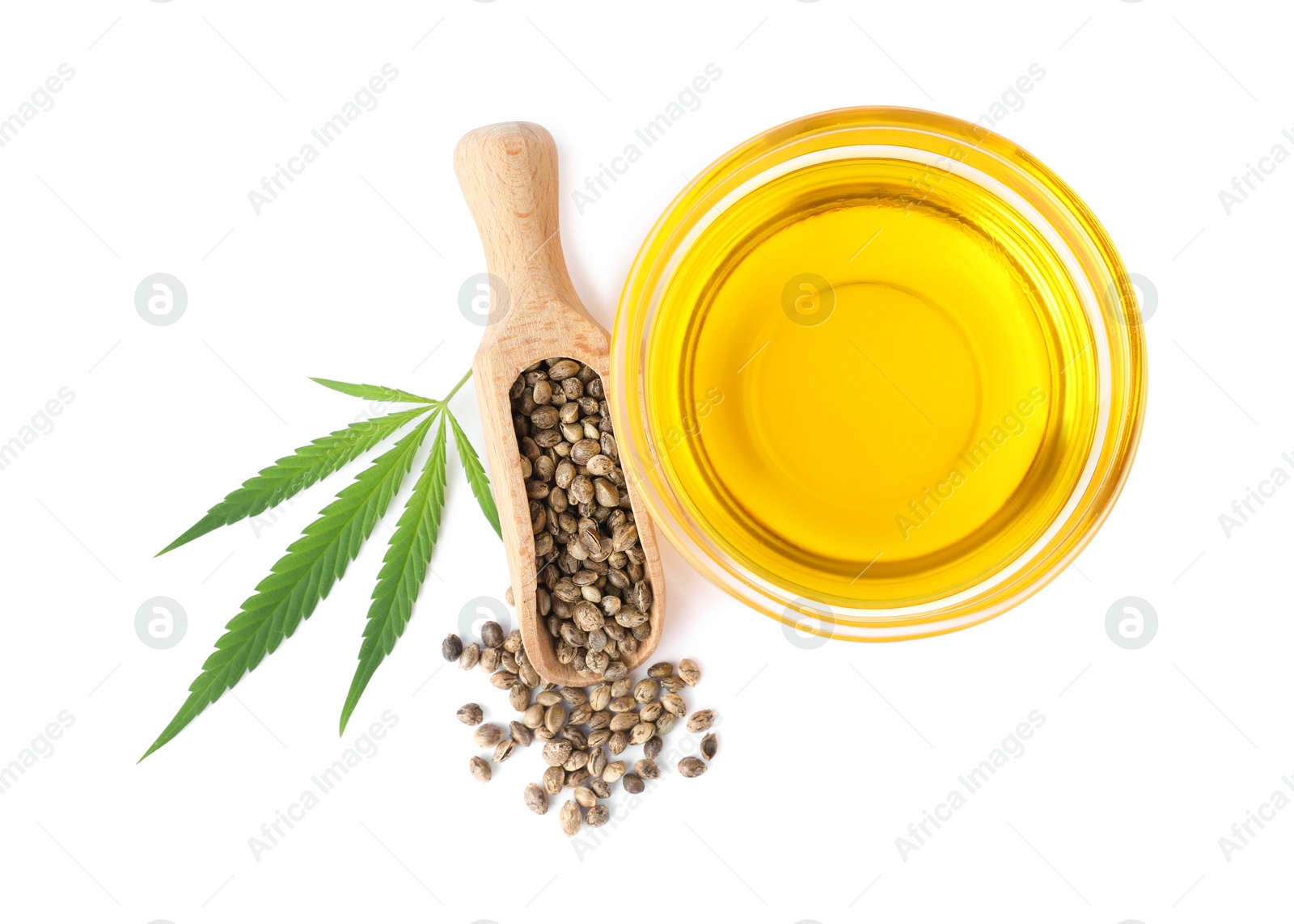 Photo of Bowl of hemp oil, fresh leaf and seeds on white background, top view