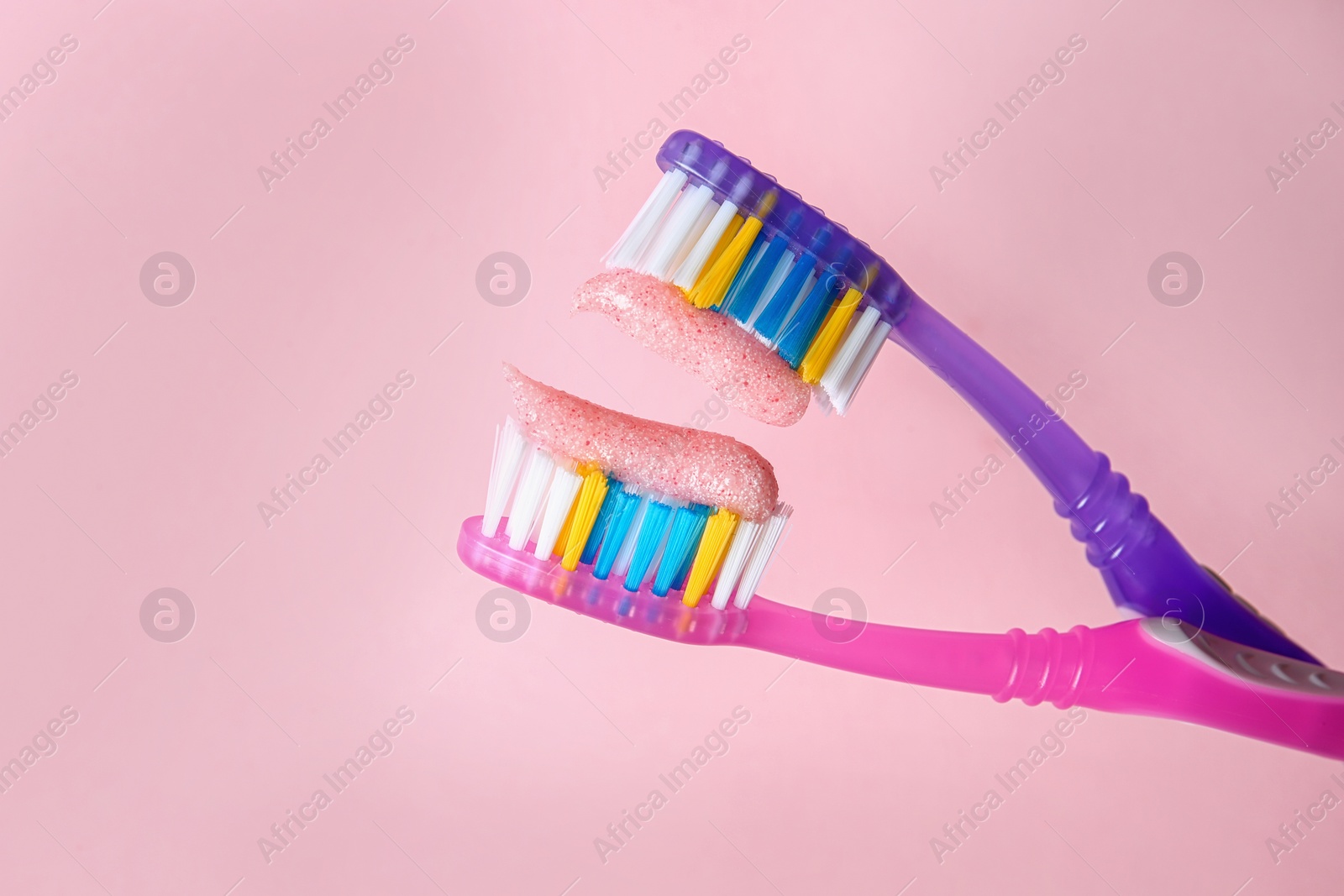 Photo of Toothbrushes with paste on color background, closeup