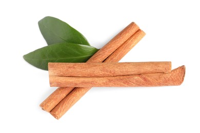 Cinnamon sticks and green leaves isolated on white, top view