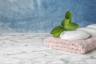 Photo of Beautiful composition with spa stones and towel on table. Space for text