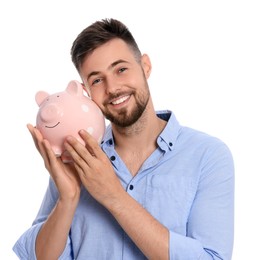 Happy young man with piggy bank on white background