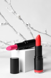 Different beautiful glossy lipsticks on white background