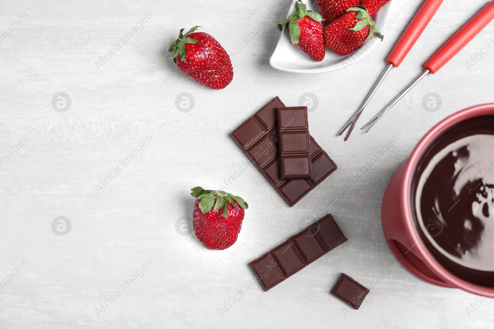 Photo of Flat lay composition with chocolate fondue and space for text on white stone background