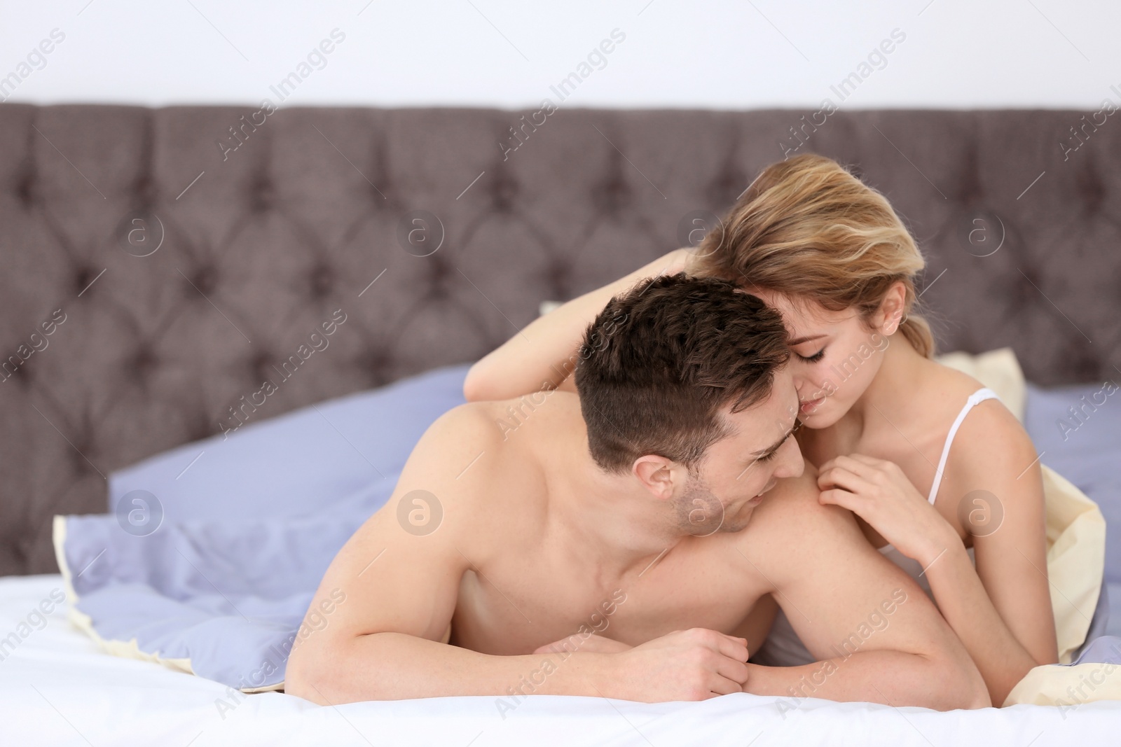 Photo of Sexy young couple being intimate in bed at home