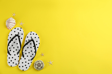Photo of Flat lay composition with flip flops on yellow background. Space for text