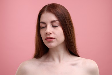 Portrait of beautiful woman with freckles on pink background