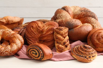 Photo of Different tasty freshly baked pastries on white table