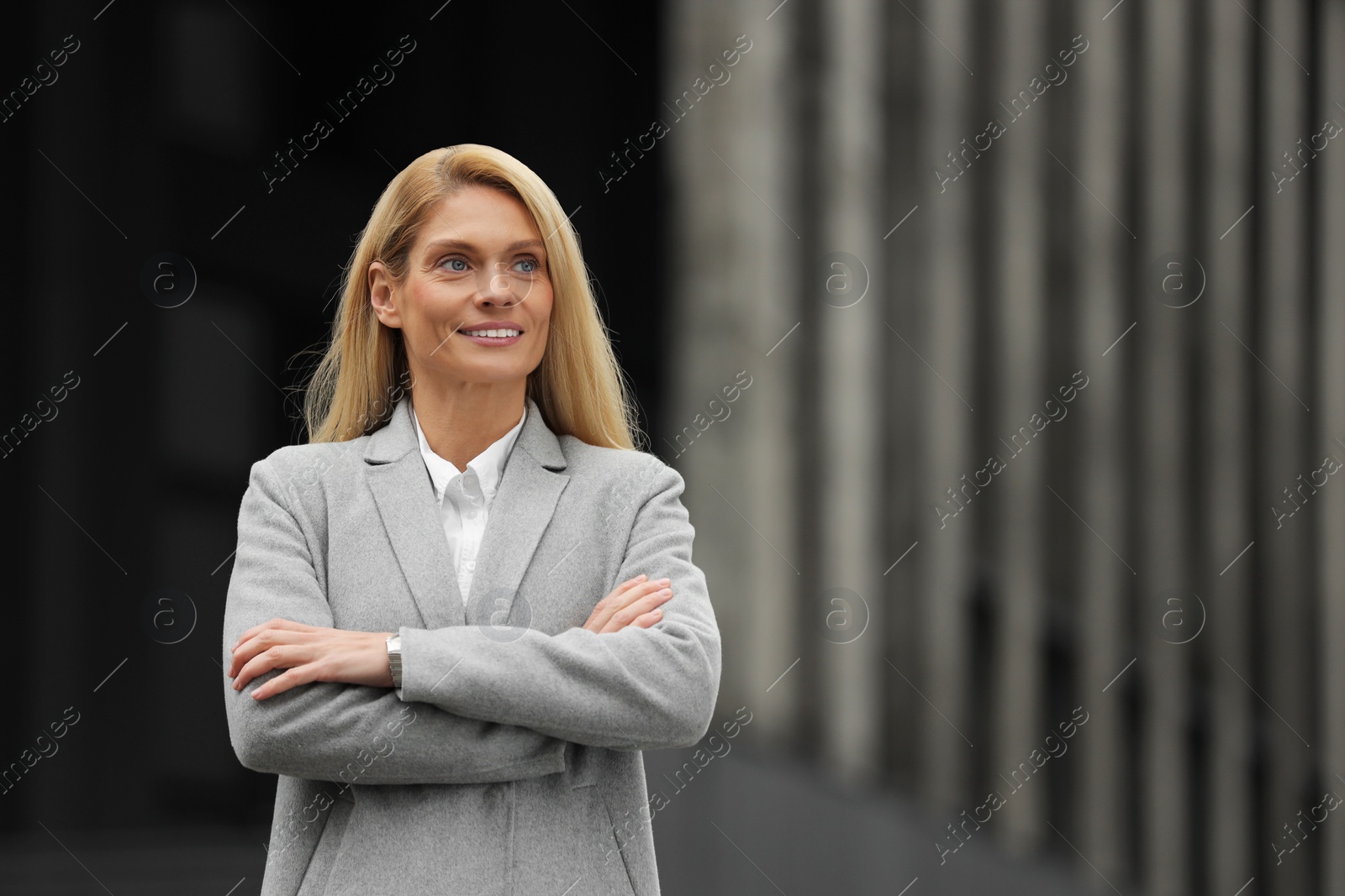 Photo of Smiling woman with crossed arms outdoors, space for text. Lawyer, businesswoman, accountant or manager