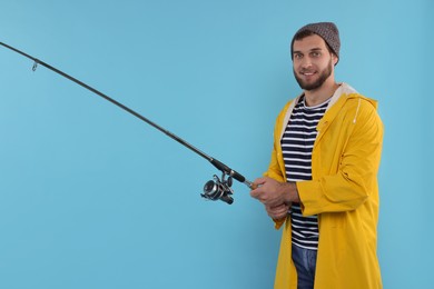 Photo of Fisherman with fishing rod on light blue background