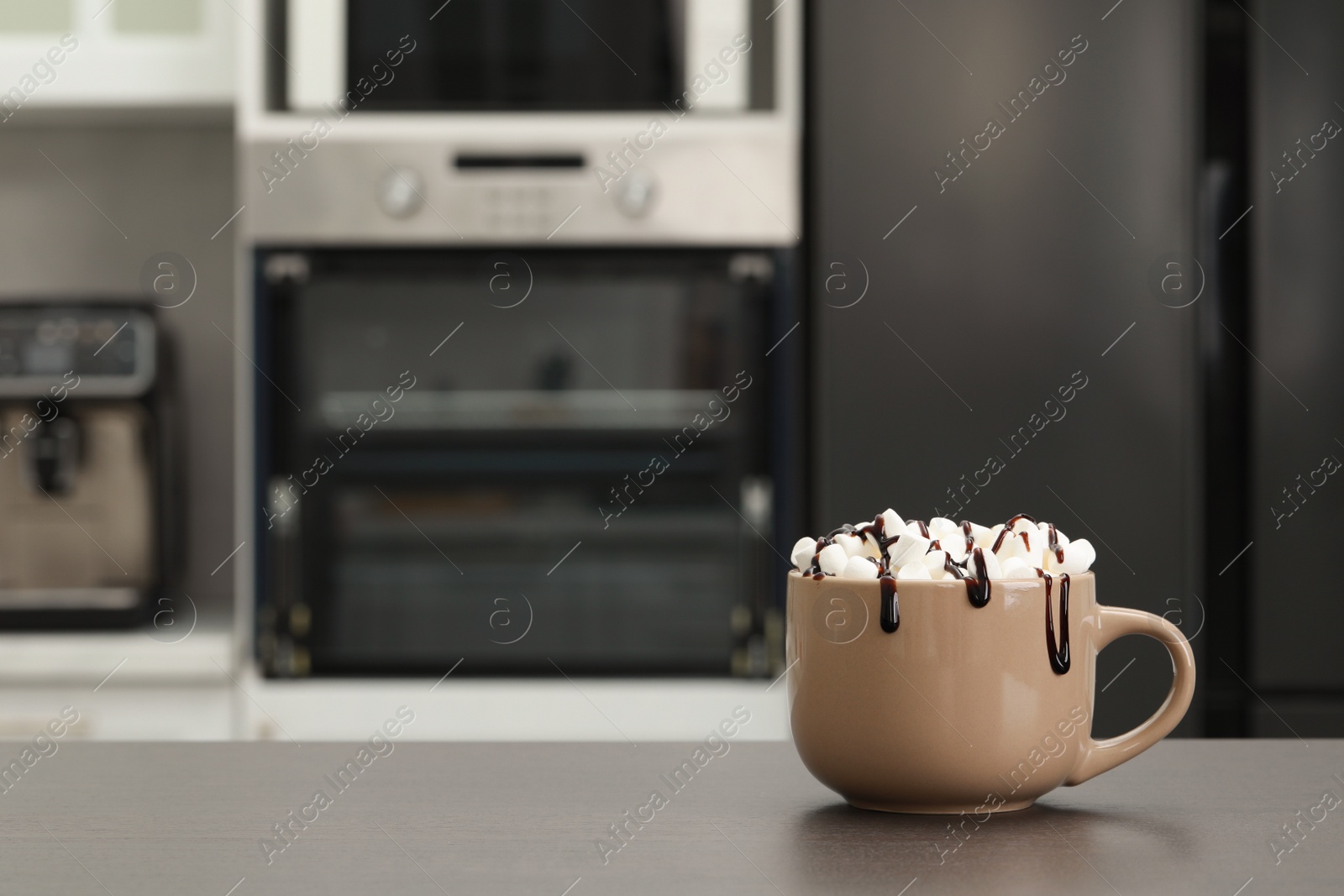 Photo of Cup of delicious drink with marshmallows and chocolate on grey table in kitchen. Space for text