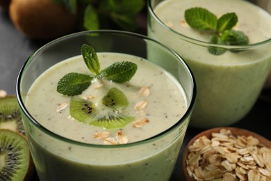 Photo of Glasses of tasty kiwi smoothie with oatmeal on table, closeup