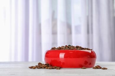 Photo of Bowl with food for cat or dog on floor. Pet care