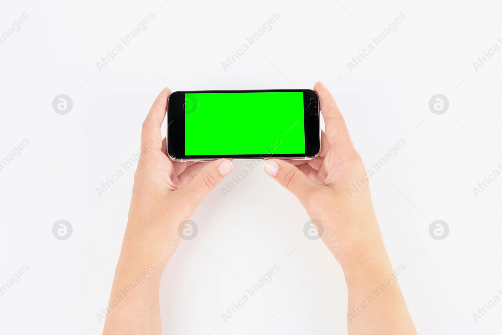 Image of Young woman holding smartphone with green screen on white background, top view. Mockup for design