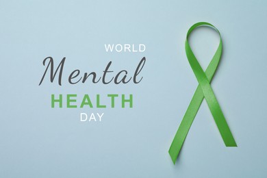 Image of World Mental Health Day. Green ribbon on light blue background, top view