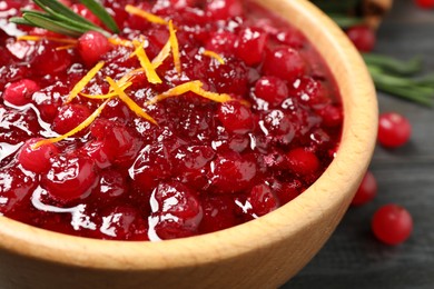 Photo of Fresh cranberry sauce with orange peel and rosemary in bowl, closeup