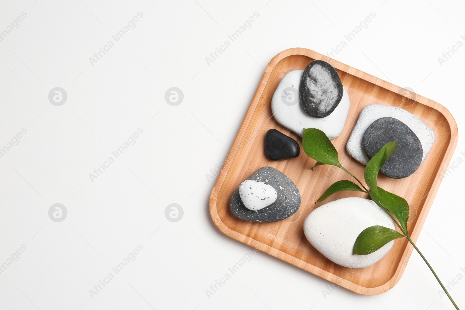 Photo of Plate with spa stones and space for text on white background, top view