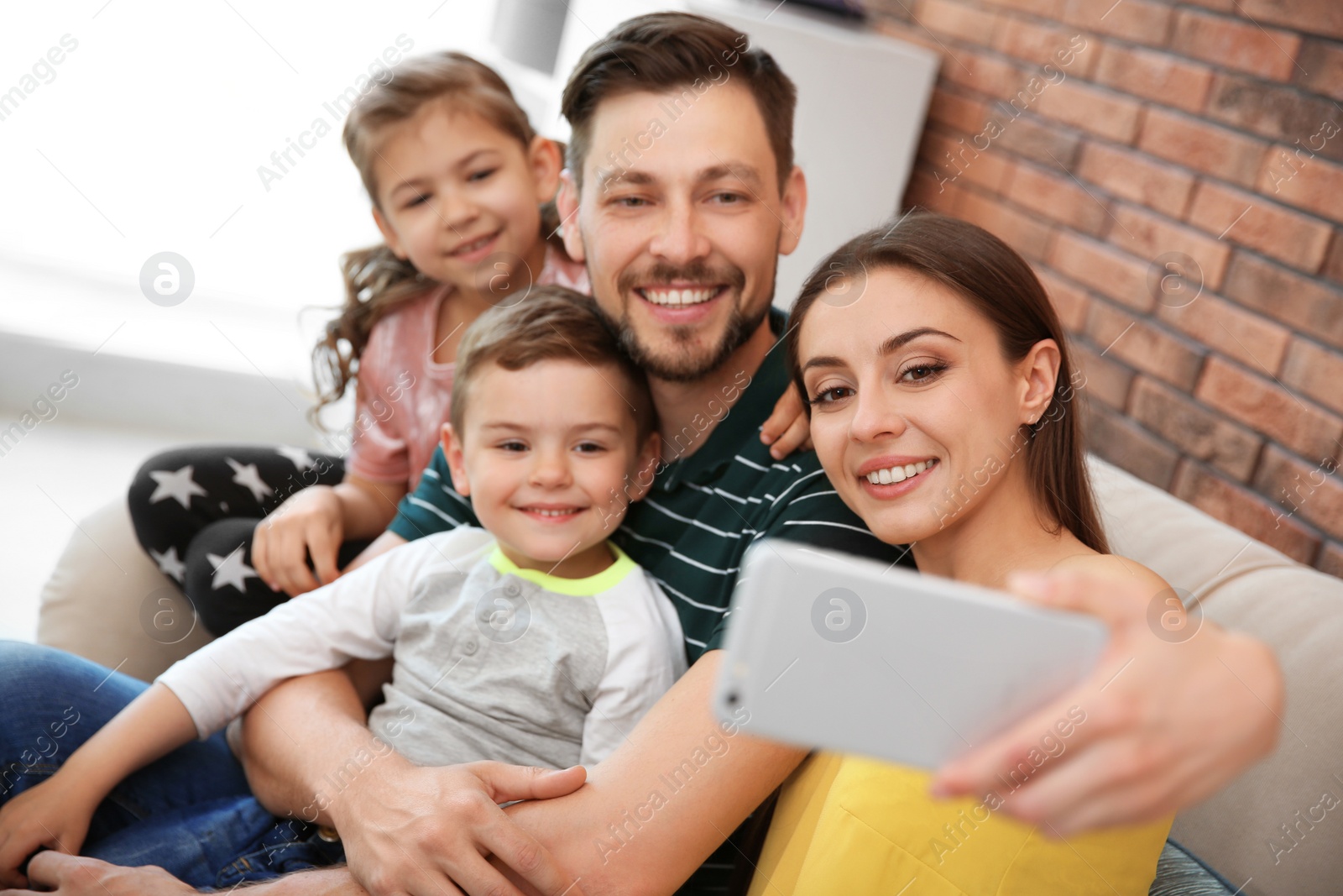 Photo of Young woman taking selfie with her family at home