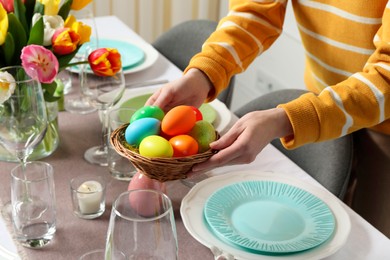 Woman setting table for festive Easter dinner at home, closeup