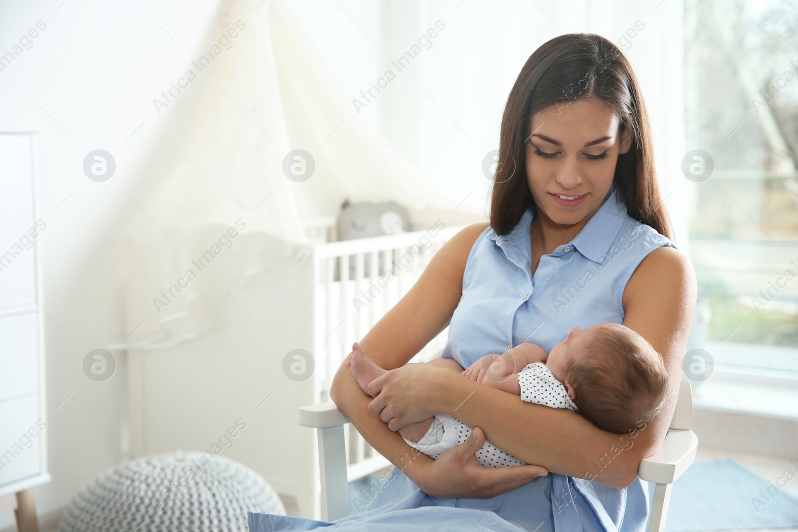 Photo of Young woman with her newborn baby at home. Space for text