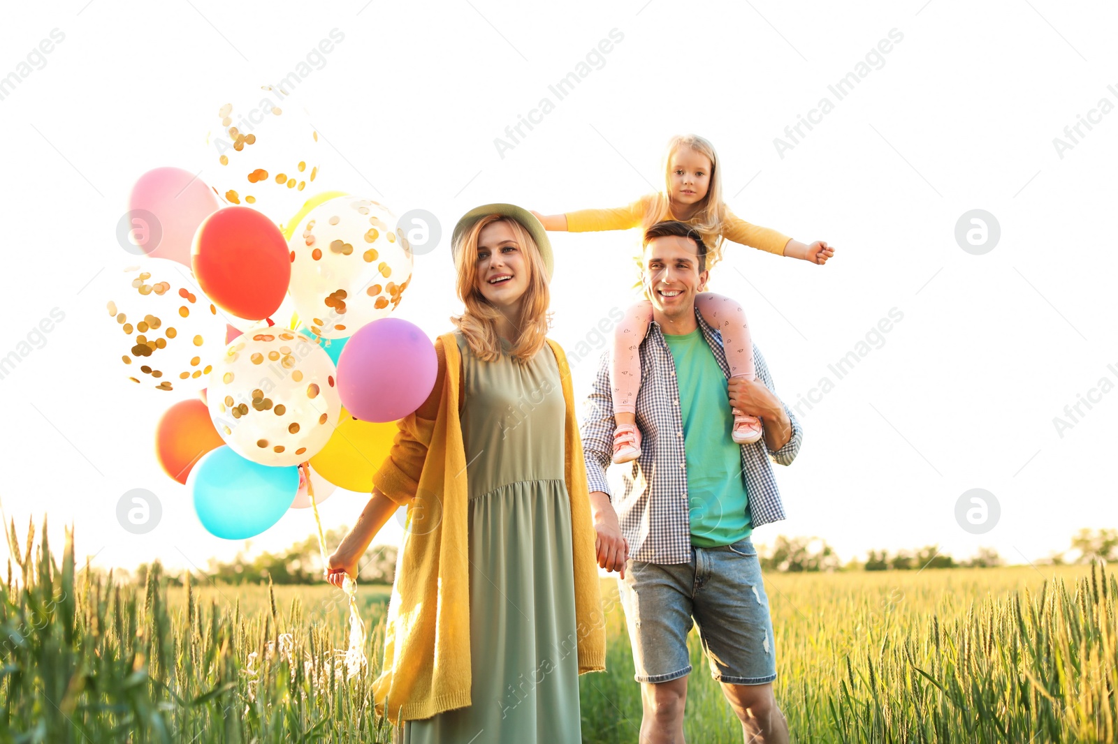 Photo of Happy family with colorful balloons outdoors on sunny day