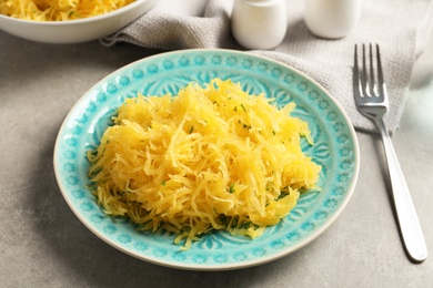 Plate with cooked spaghetti squash on table