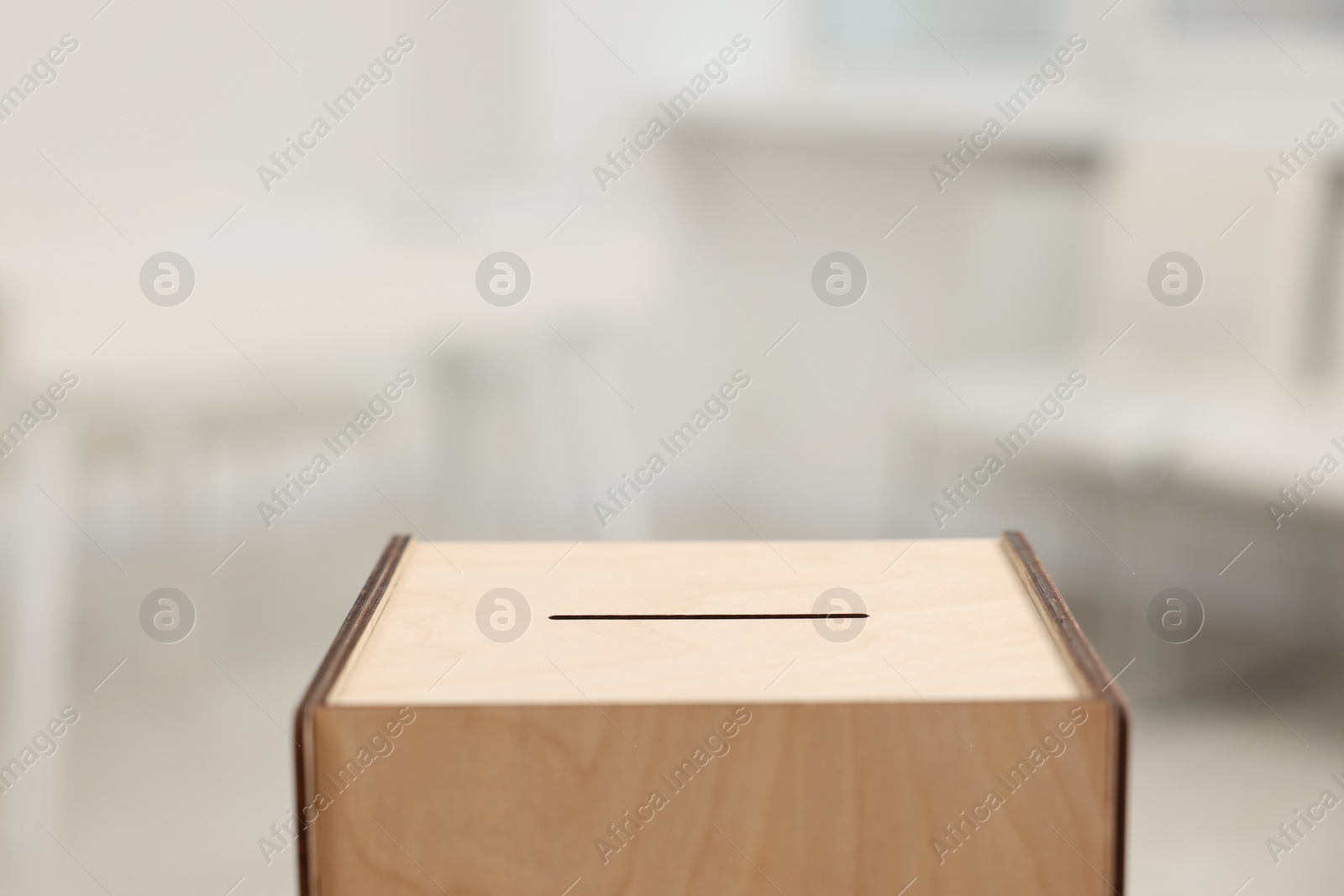 Photo of Wooden ballot box on blurred background, closeup. Space for text