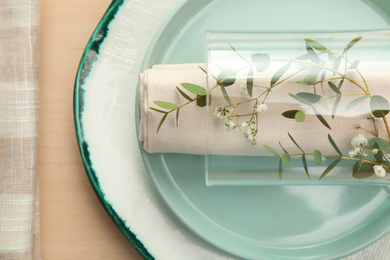 Photo of Elegant table setting with flowers and leaves, closeup