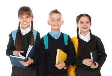 Portrait of cute children in school uniform with backpacks and books on white background